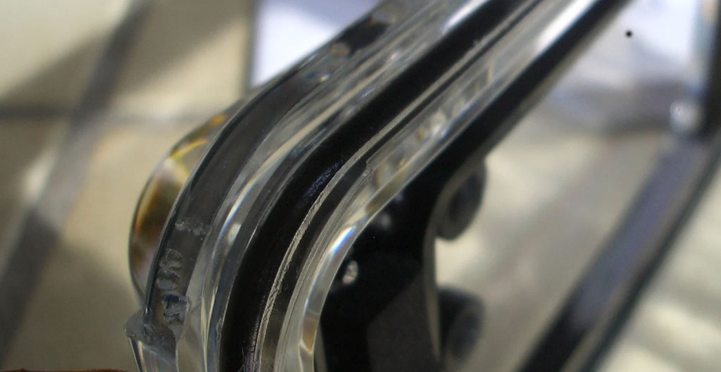 Icône en design plat représentant une goutte d'eau bleue avec une loupe examinant un joint d'étanchéité circulaire, symbolisant la vérification minutieuse avant immersion